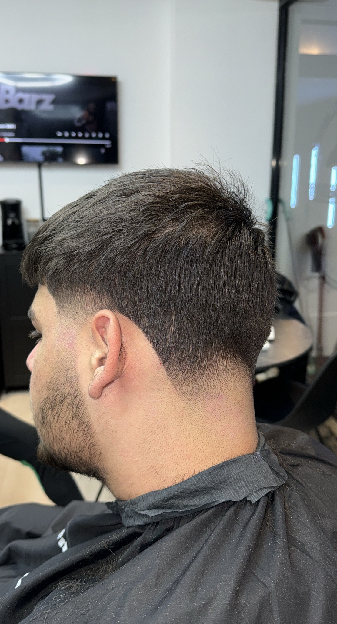 Taper fade met getextureerde bovenkant, van achteren gezien