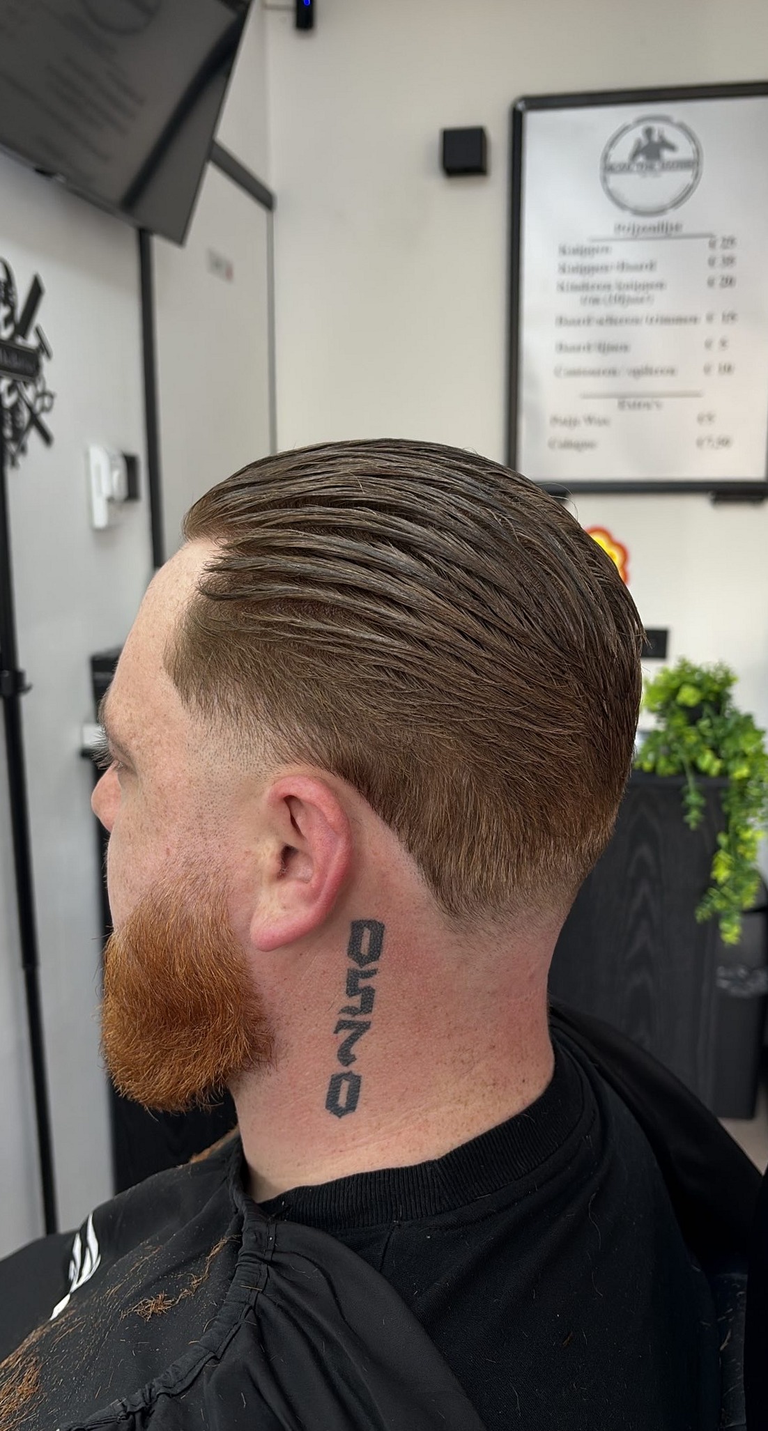 Slick-back met een verzorgde rode baard, van opzij